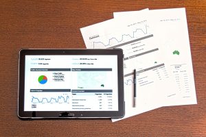 iPad and documents with graphs and charts