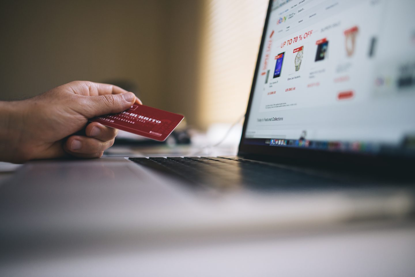 laptop with person holding credit card